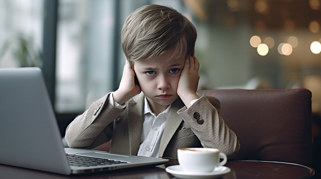 Well dressed boy looks sad with hands over ears