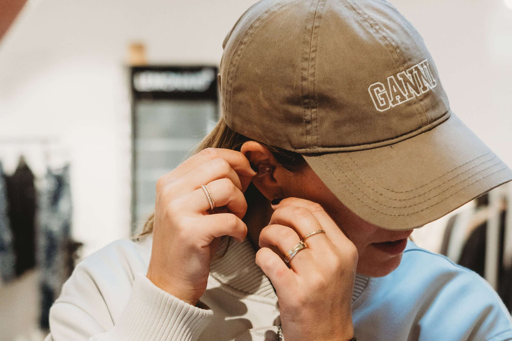Person wearing a beige cap with inserting the Earasers.