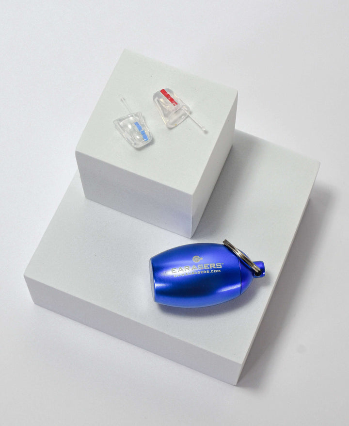 Blue canister laying on white box with earplugs on another white box above it on a white background