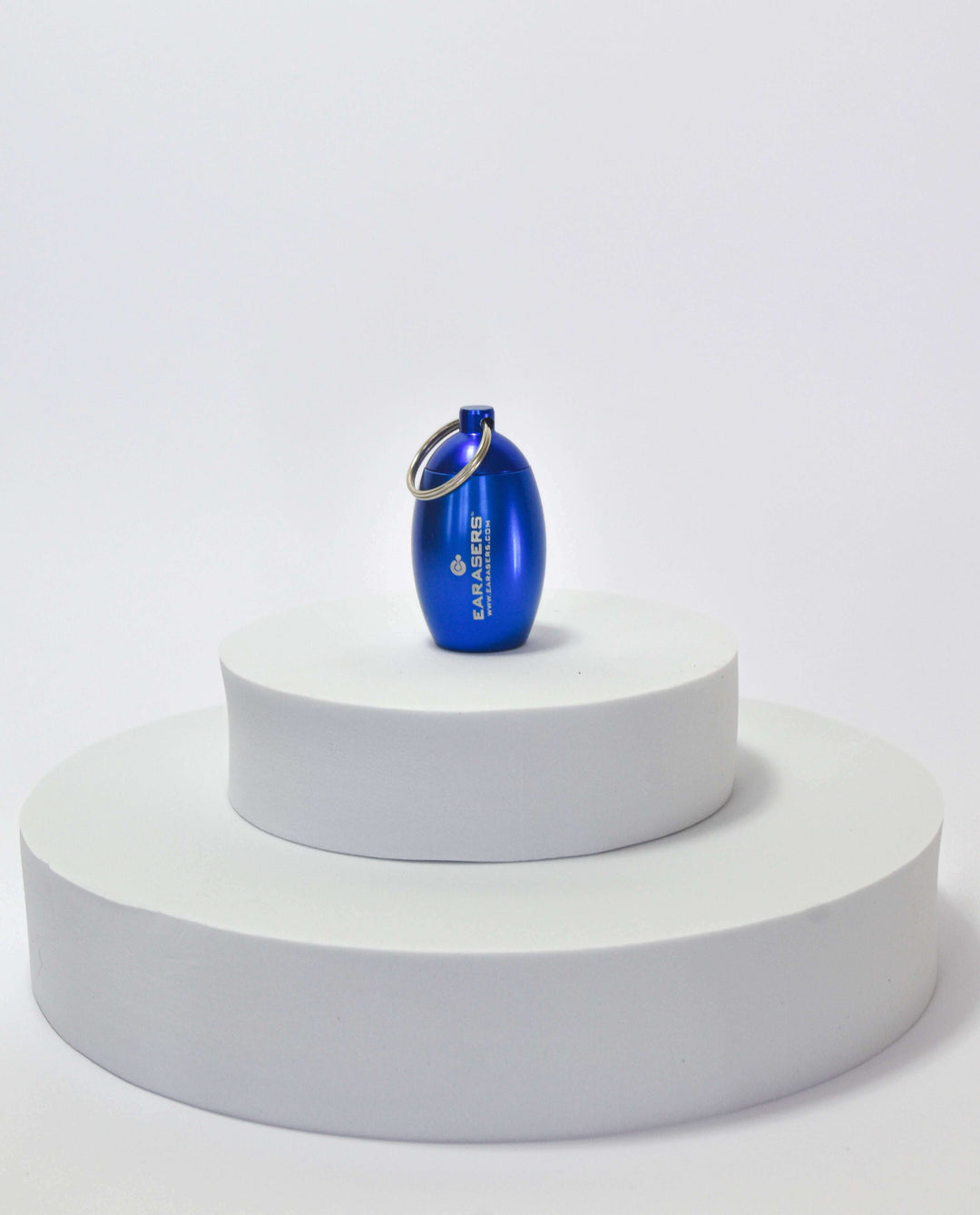 Blue bottle-shaped canister on a white cylindrical stand with a white background