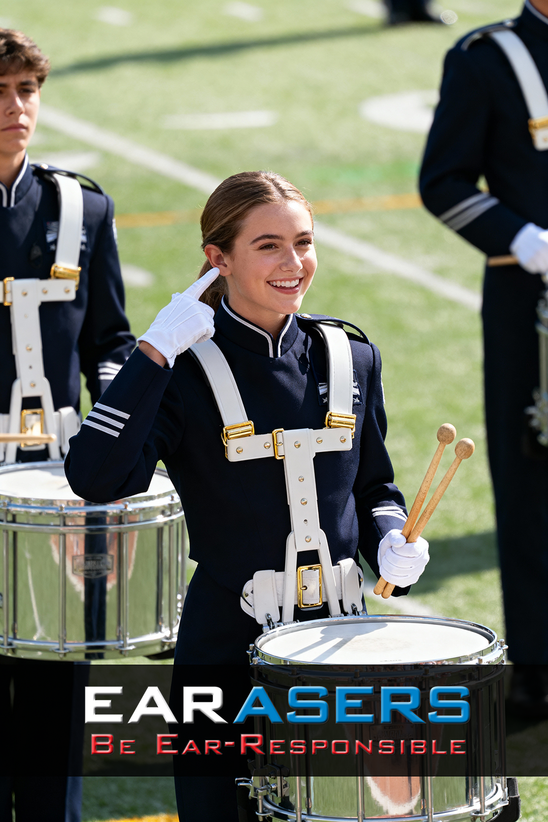 Person in marching band uniform with drum, standing on a field with 'Earasers' advertisement text.