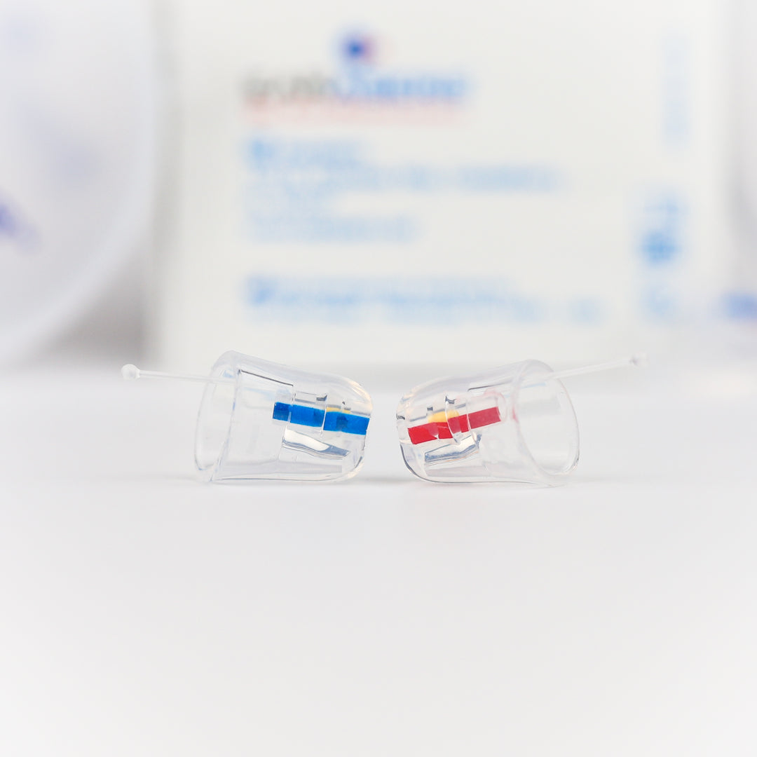 A pair of clear Earasers with blue and red filters lying in front of an Earasers box