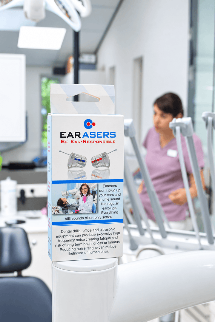 Earasers box sits on top of a dental workstation in a dentist's office with a dental hygienist in the background