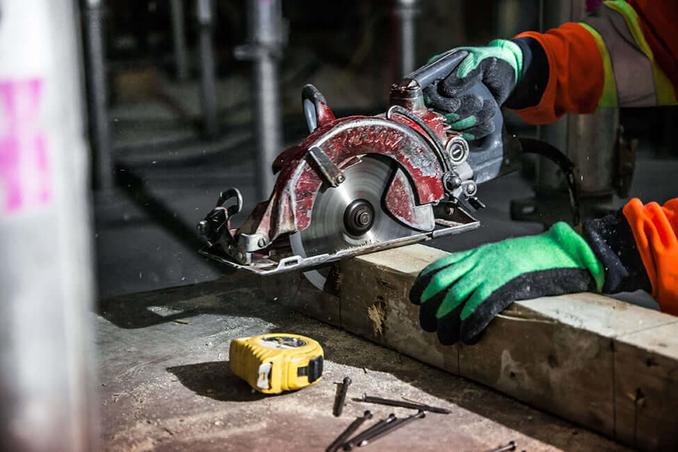 Person using circular saw to cut beam