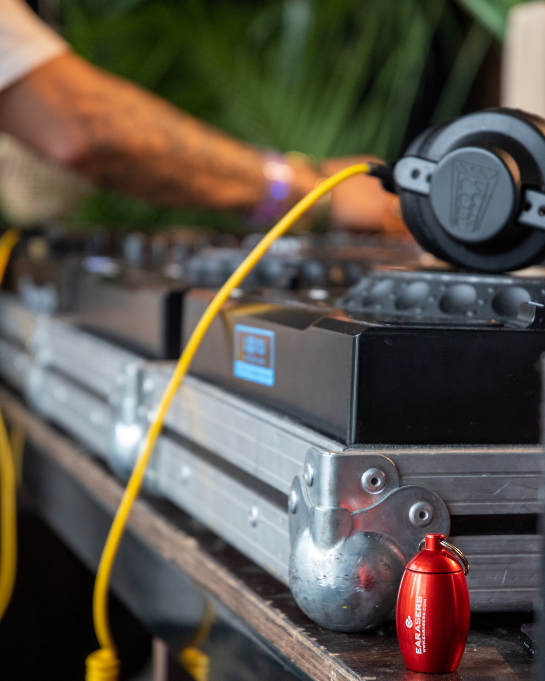 DJ equipment with headphones and a red stashcan earasers container on a table